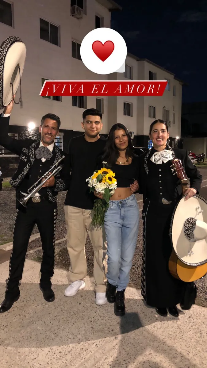 Una pareja con un ramo de girasoles junto al dúo Experiencia Guadalupe