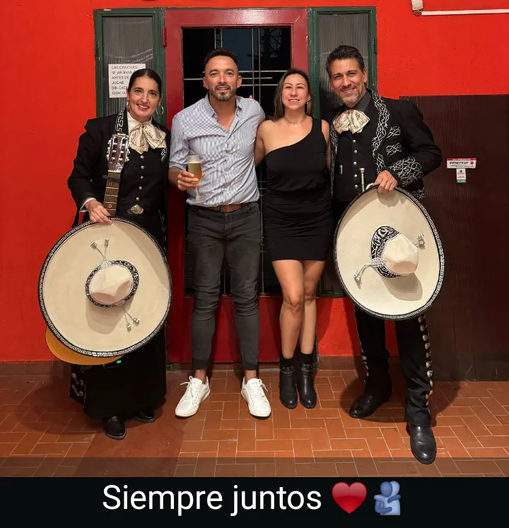 Una pareja posa entre los dos mariachis de Experiencia Guadalupe, con la leyenda «Siempre juntos»