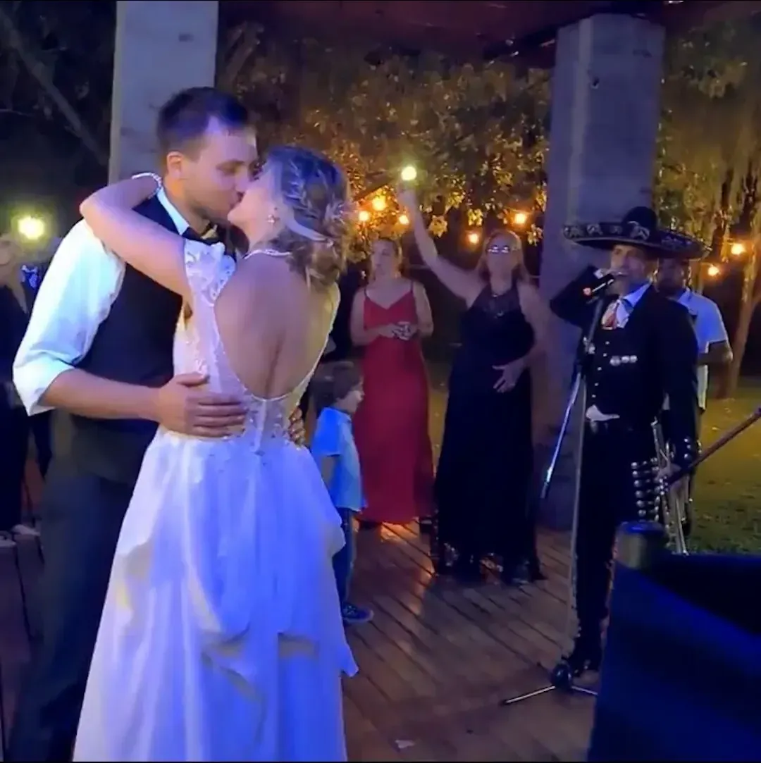 Los novios bailan al aire libre mientras el mariachi les canta