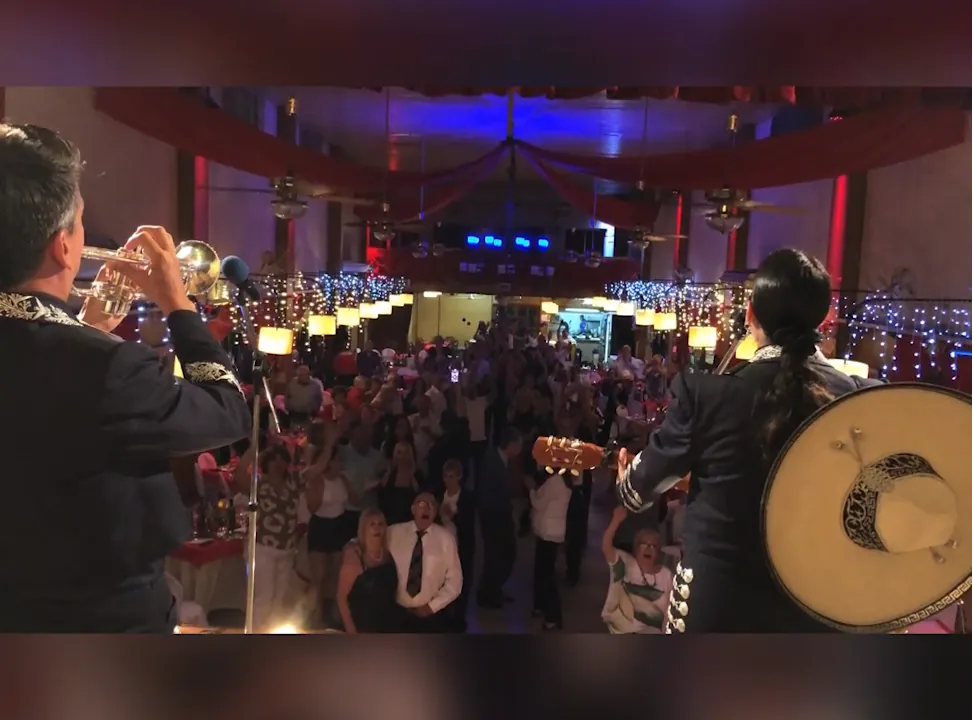 Los mariachis tocan frente a un salón lleno de invitados