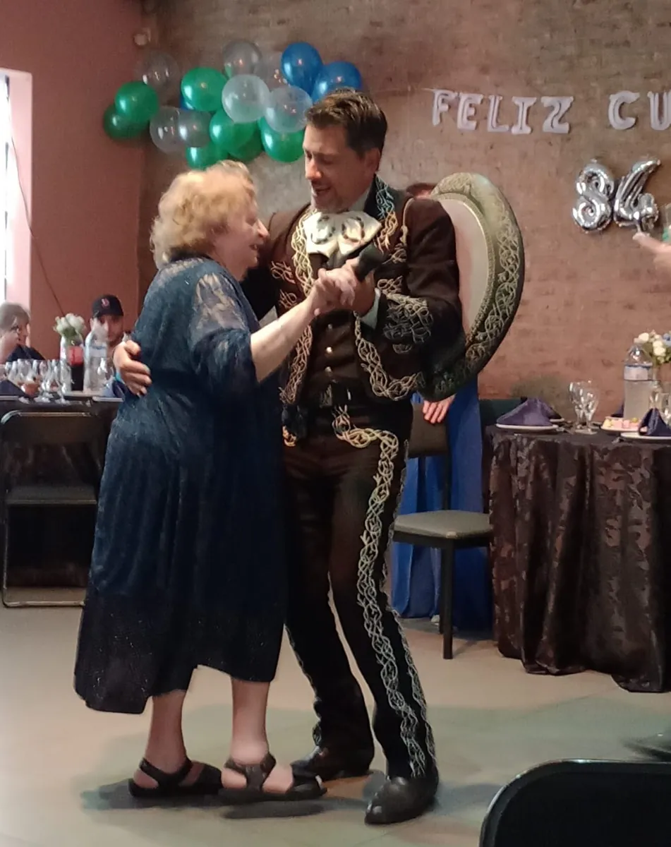 La homenajeada baila con el cantante de Experiencia Guadalupe en su cumpleaños