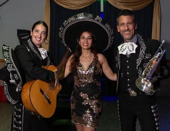 Festejo de cumpleaños: una invitada con sombrero de mariachi junto al dúo Experiencia Guadalupe
