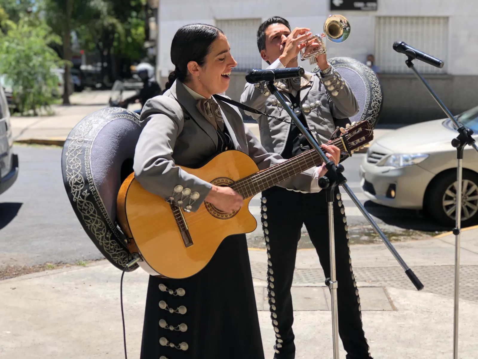Serenata en la vereda: la guitarrista y el trompetista de Experiencia Guadalupe cantan al aire libre